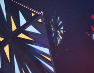 Motifs géométriques lumineux en triangles colorés projetés sur un mur sombre dans un environnement intérieur.